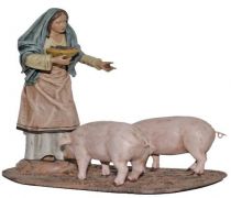 Pastora dando de comer a cerdos